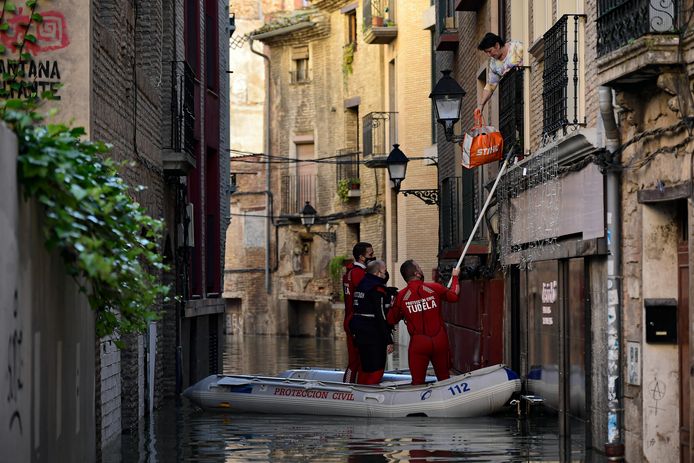 A rescue team evacuates a woman near the Ebro River.