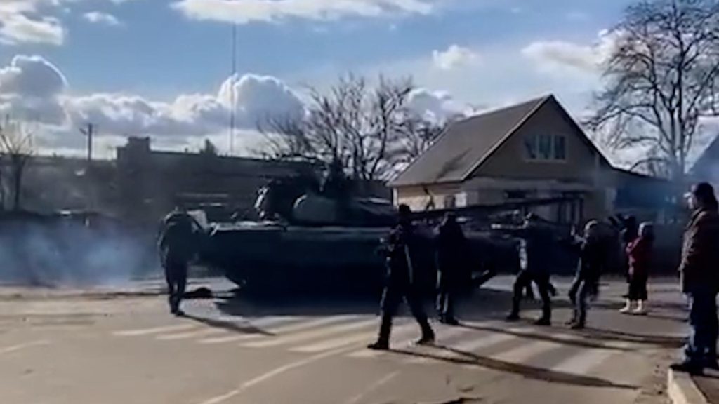 Ukrainian citizen climbs on a tank to stop the Russian army