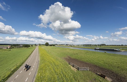 Basic flood defense: a dam in reclaimed land with blue skies and clouds