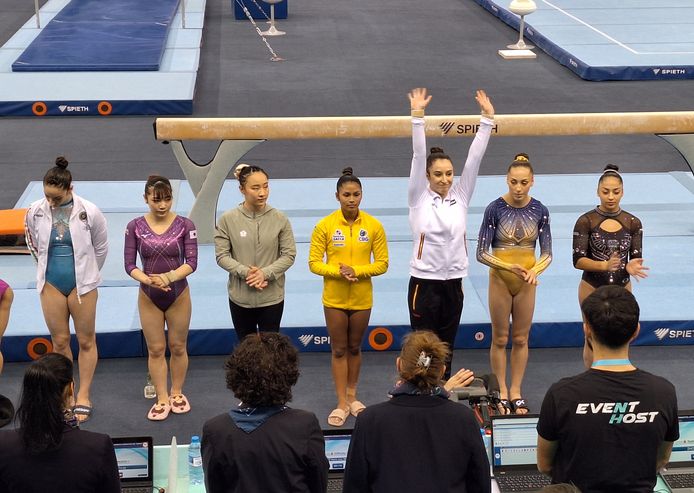 Nina Druel greets the judges and audience before the start of the beam final in Baku.