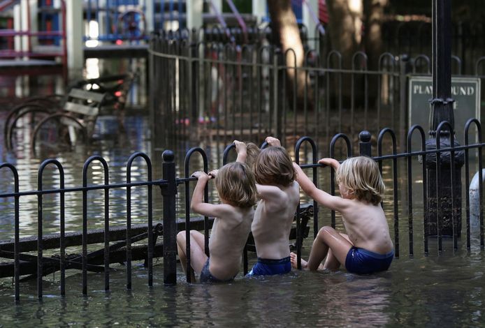 Children play in a flooded playground in Brooklyn, New York City.